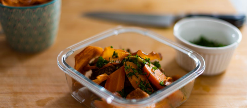 Plat à emporter gourmand dans un contenant consigné d'effiloché de boeuf, carotte rôtie, chips de patate douce